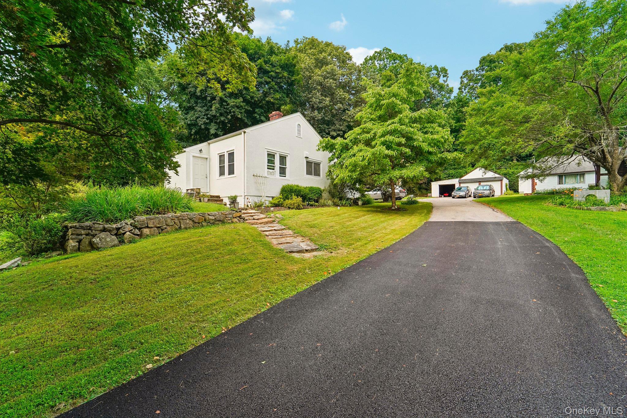 Set back from the road on a picturesque, tree-lined property, this inv...