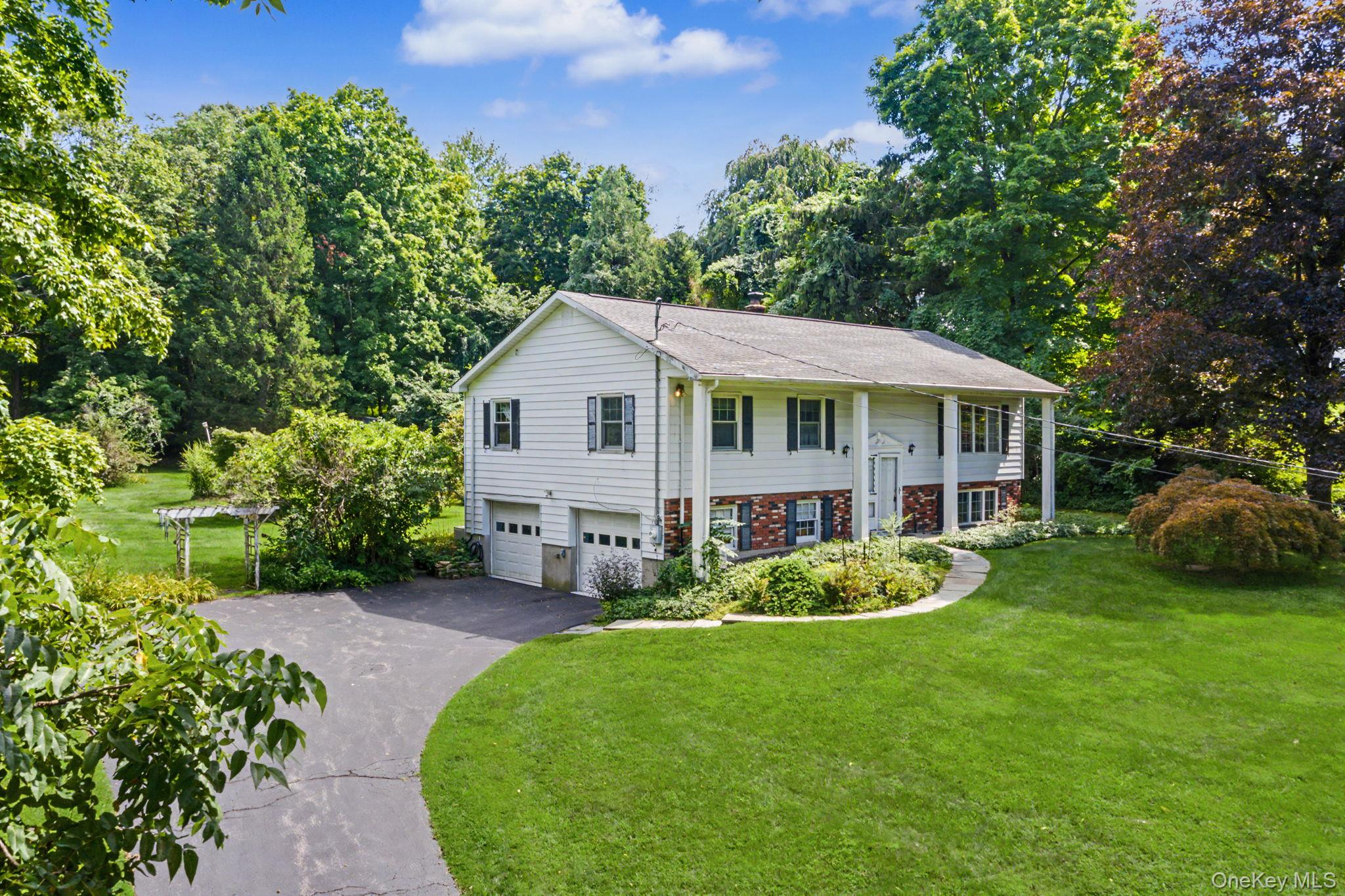 The stone wall lined driveway rises from street level and leads you to...