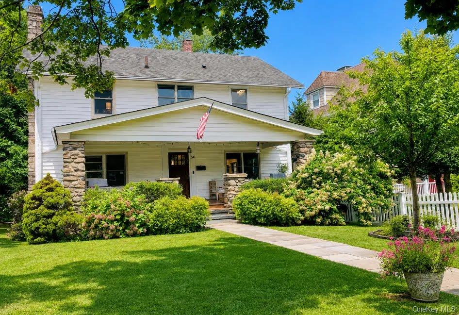 A welcoming front porch introduces this beautifully updated 1920 Ameri...