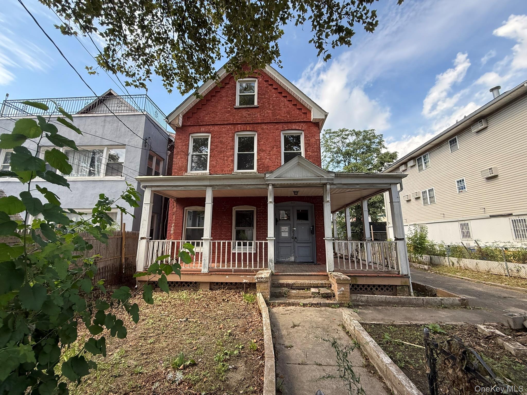 Stately brick two-family home offering impressive curb appeal, a charm...