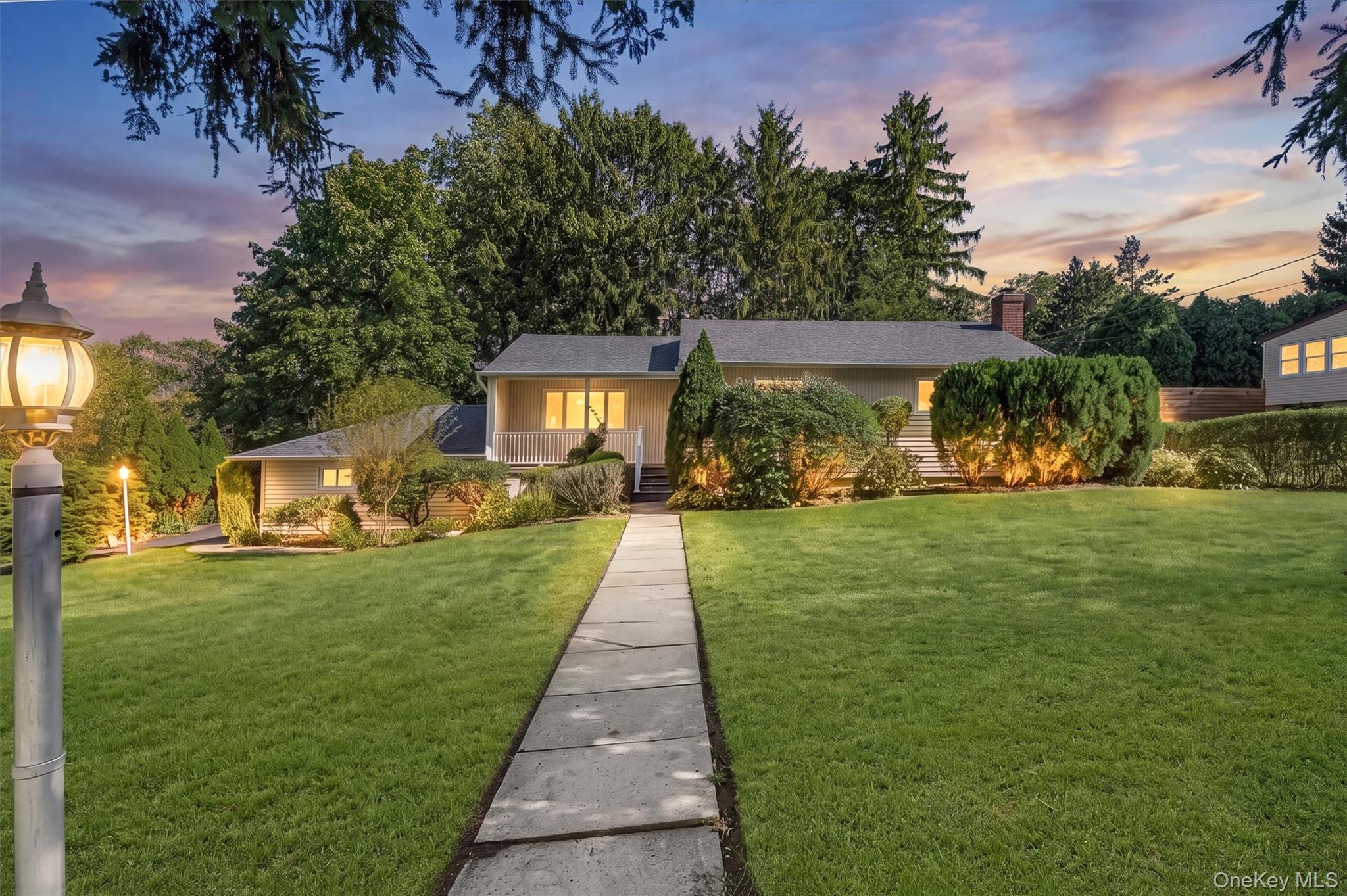 Privately positioned on a corner property in Hartsdale’s sought-after...