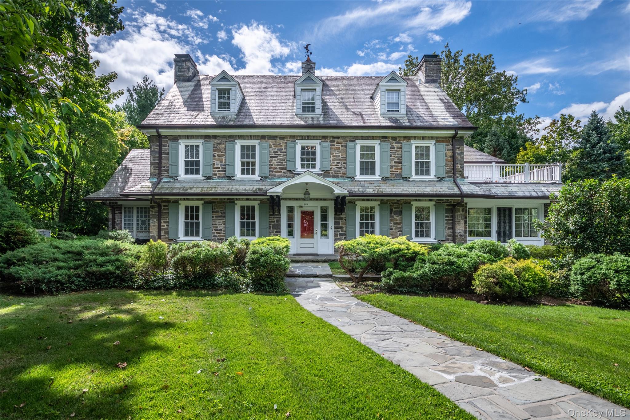 A distinguished 1922 Center Hall Stone Colonial set on .77 acres of be...