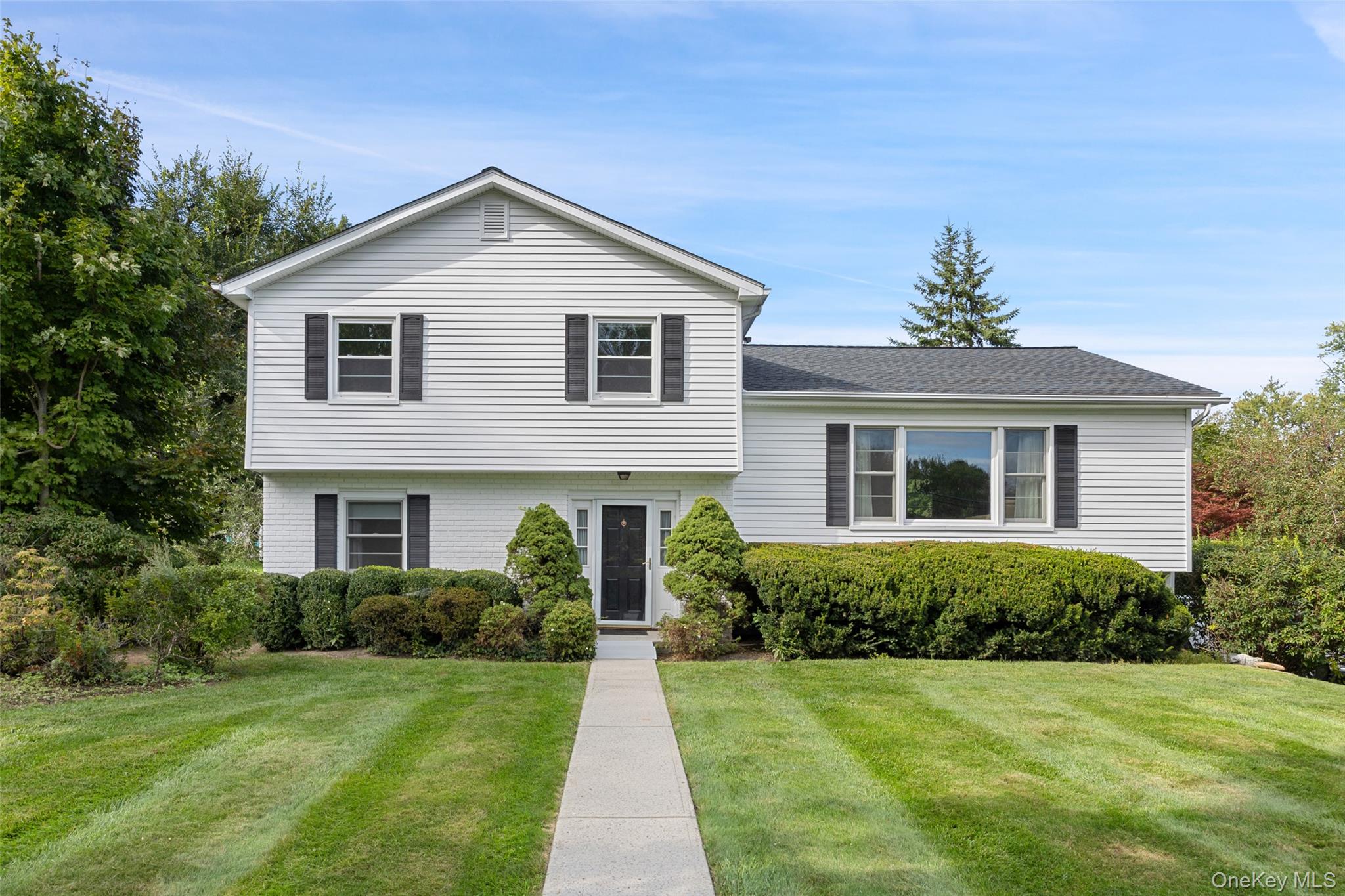 Picture perfect front lawn frames this freshly painted, spacious split...