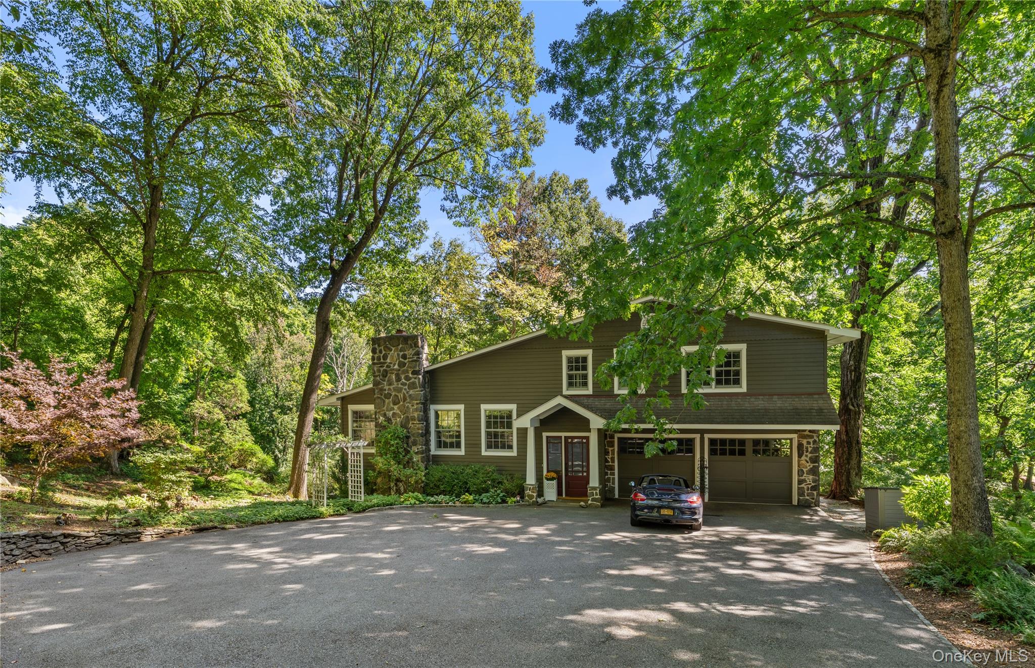 Tucked beneath a canopy of mature trees on just over a wooded acre at...