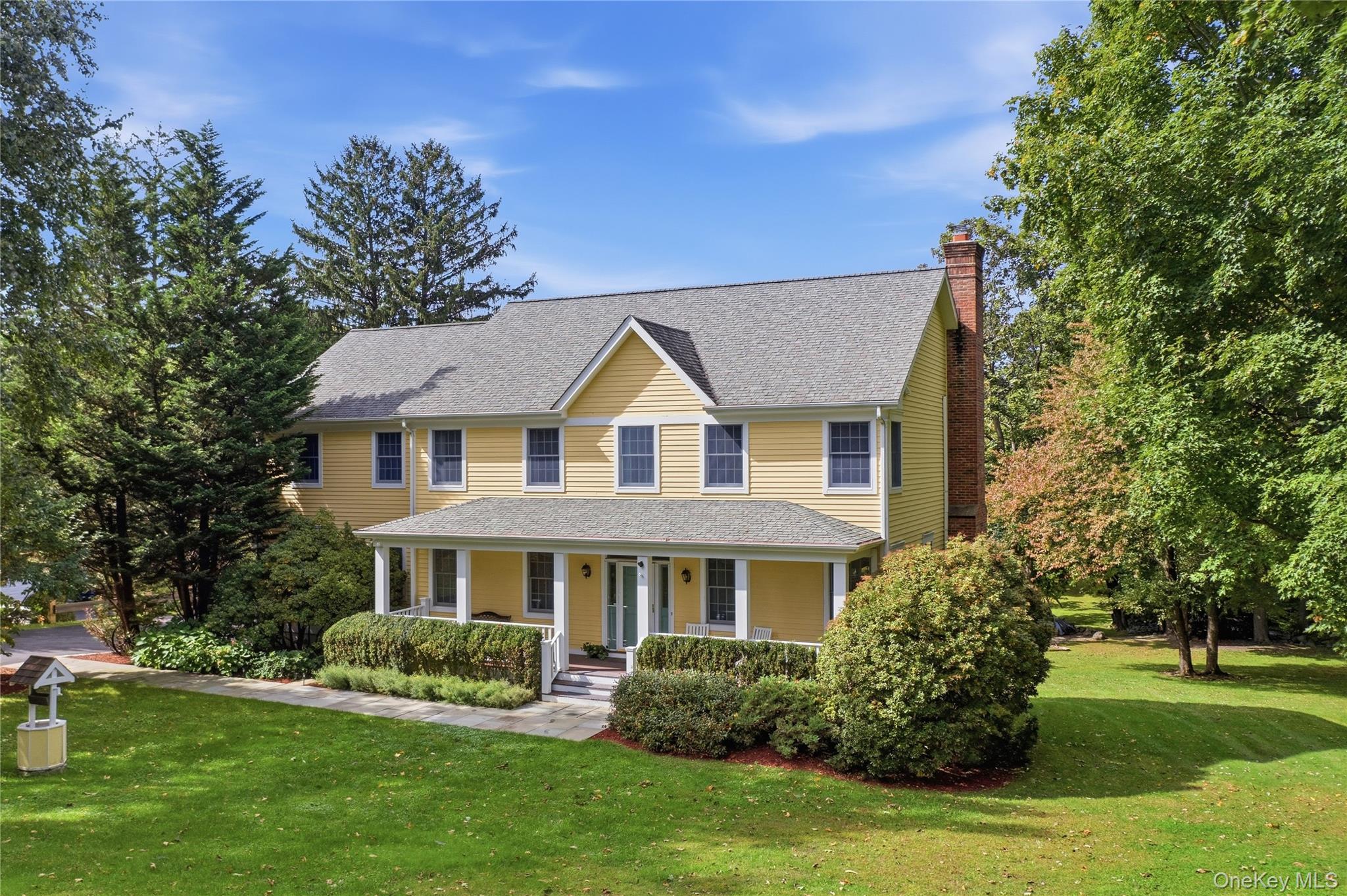 Set against a backdrop of lush landscaping, rustic stone walls, panora...