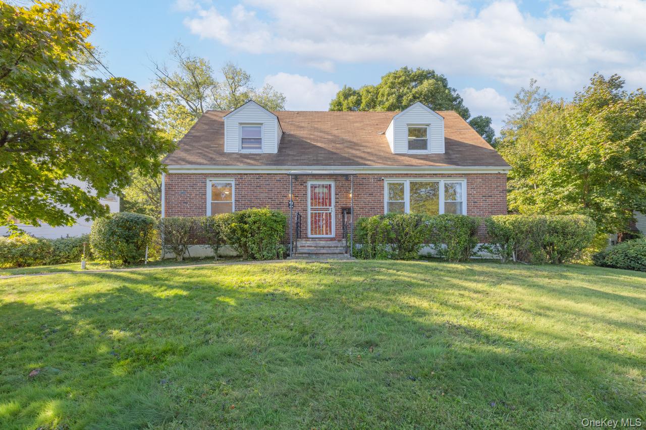 Sitting pretty on the top of a grassy knoll, this brick cape cod has t...