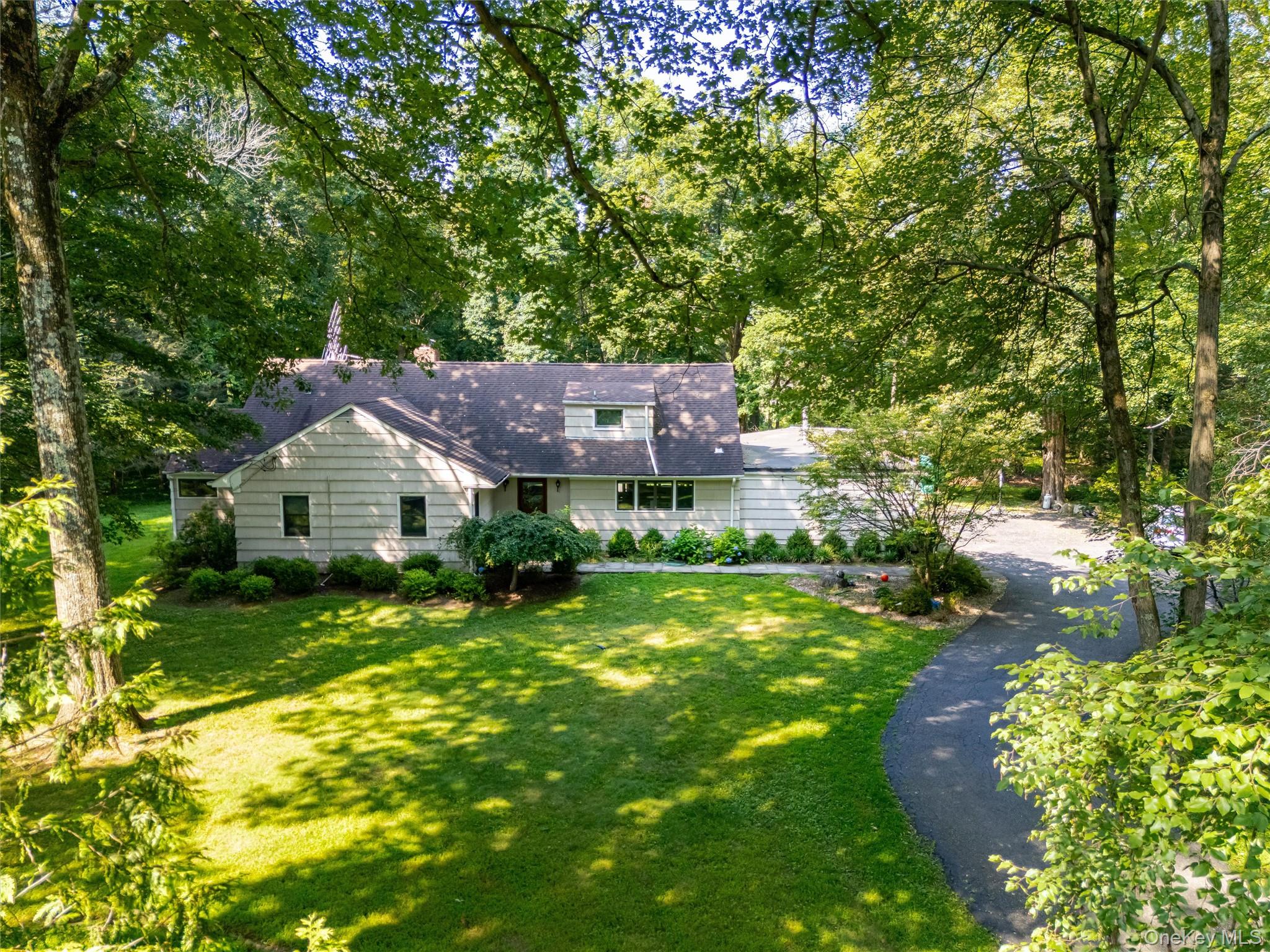 Tucked back on a private corner lot on one of Chappaqua’s most desirab...
