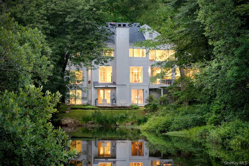 Tucked beside a peaceful pond in Pound Ridge, this contemporary retrea...