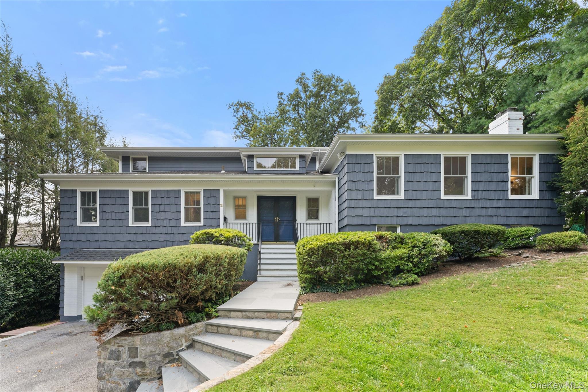 Sited high above the street on corner property, this updated mid-centu...