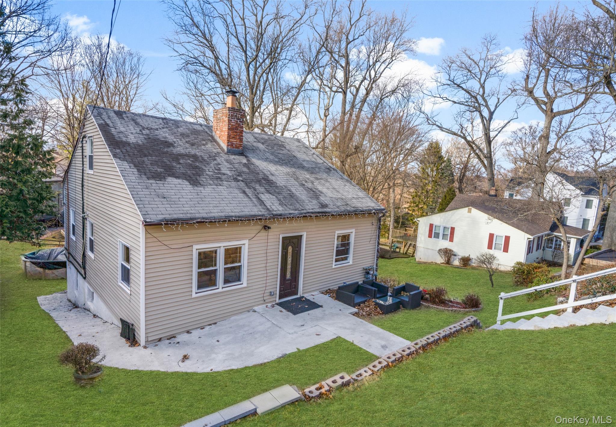 Fully renovated Cape Cod home with an inviting front patio boasting mo...