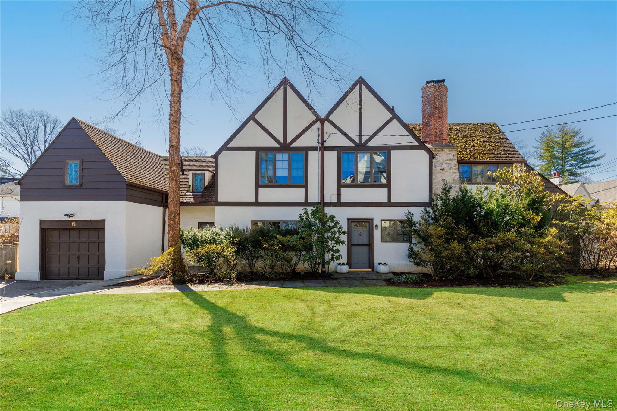 With its steeply pitched gables and textured stucco facade accented by...