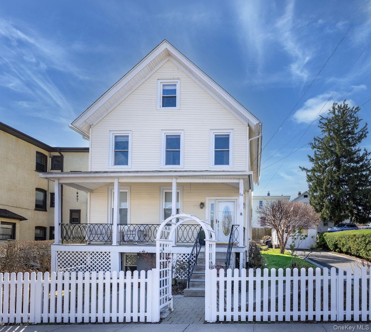 A timeless rocking chair front porch and picket fence enhance the curb...