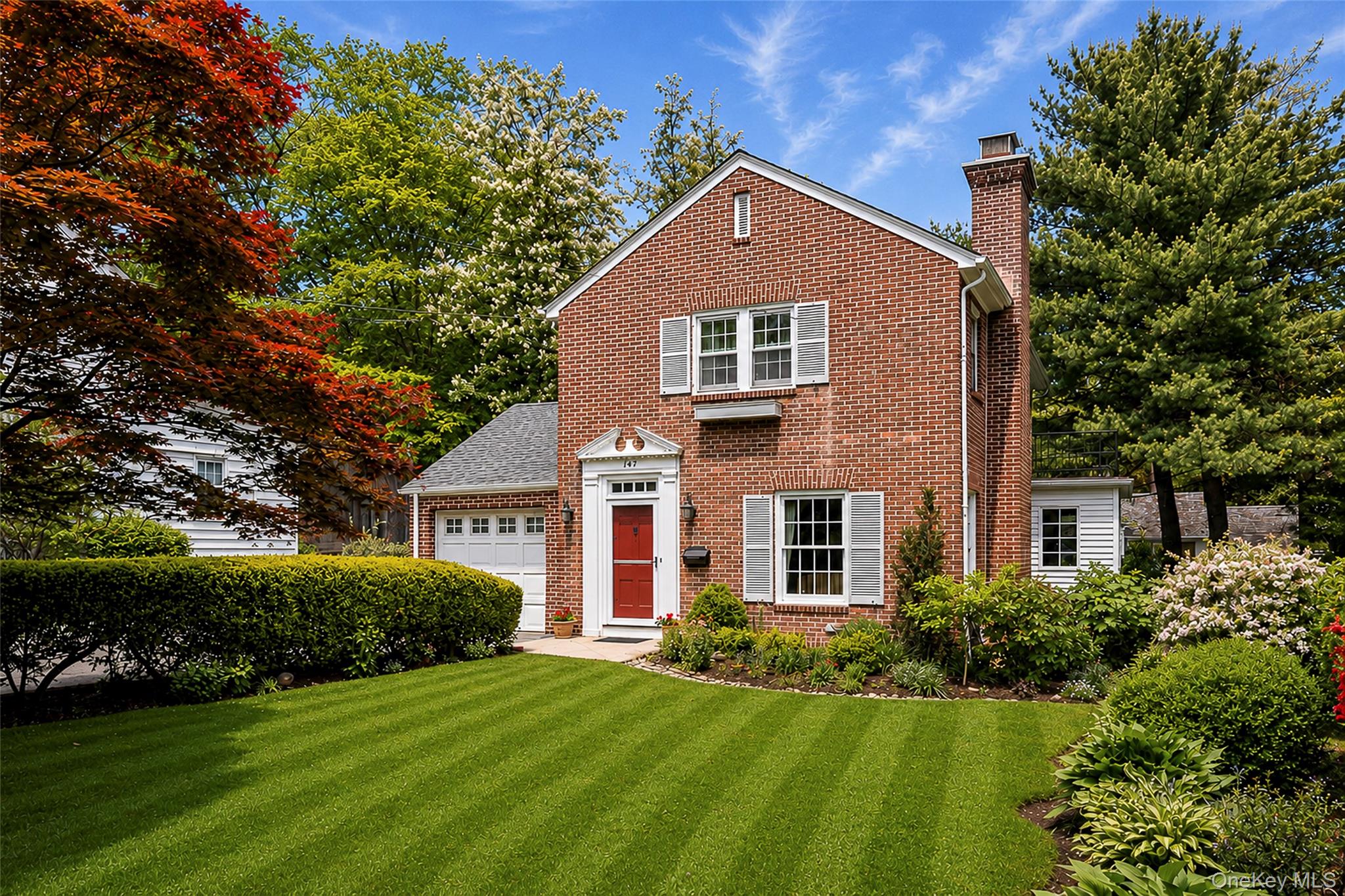 147 Ridgeway is a red brick home with a white picket fence located on...
